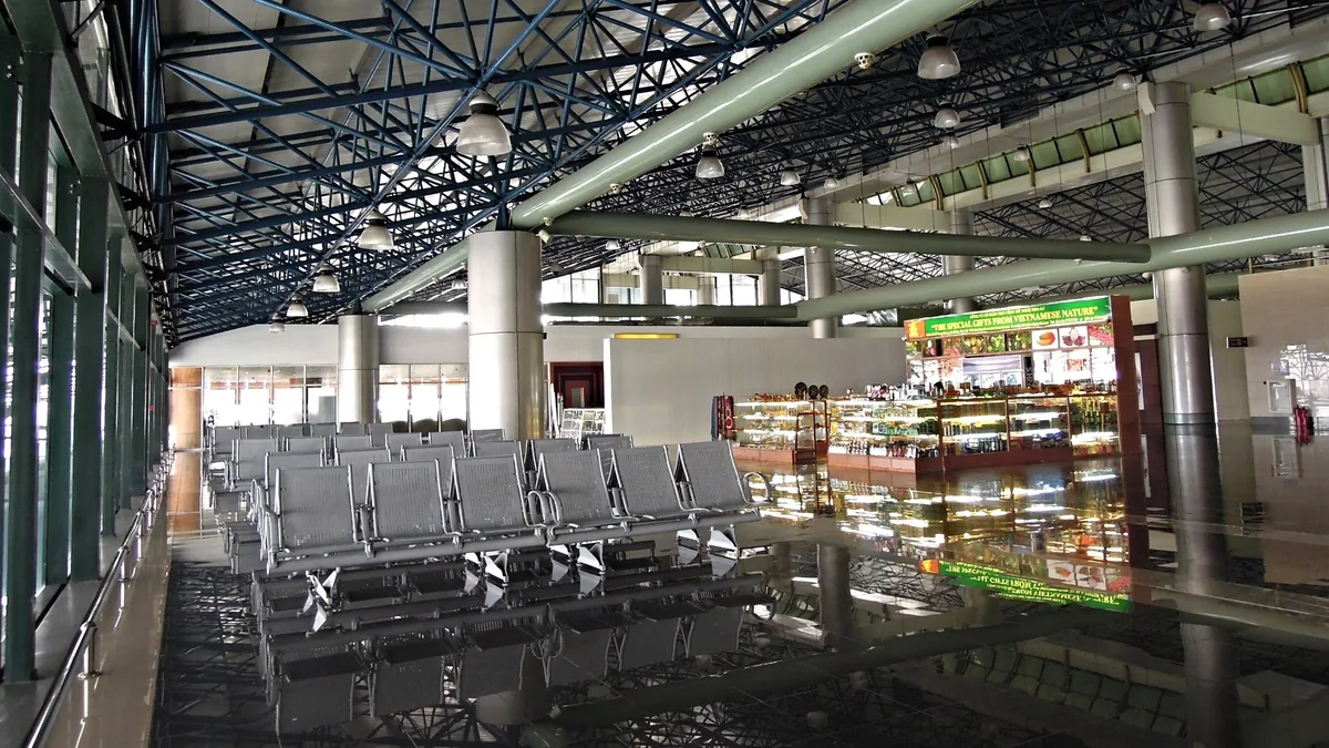 Những hàng ghế trống và sàn nhà phản chiếu lấp đầy khu vực chờ vắng vẻ tại sân bay quốc tế Nội Bài, Hà Nội.